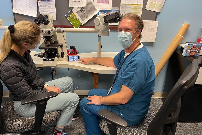 A medical doctor and a student with an OpenFlexure Microscope