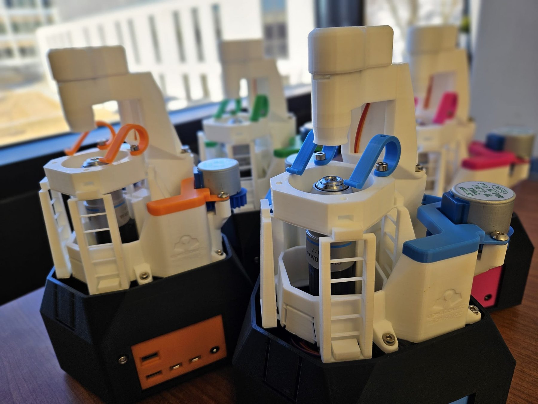 A fleet of 4 microscopes with different coloured highlights.